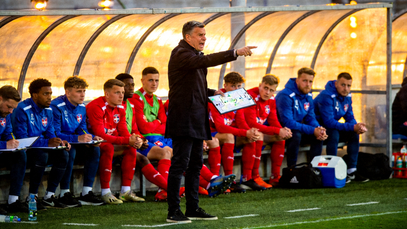 足球教练在场边指挥 - 教练与替补席球员